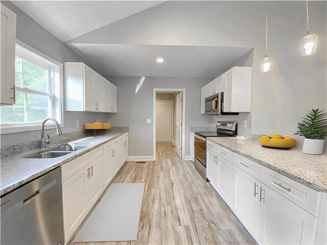 325 Code Cir, Seneca, SC 29678 - kitchen with stainless steel appliances, lofted ceiling, white cabinetry, light wood-style flooring, and light stone counters