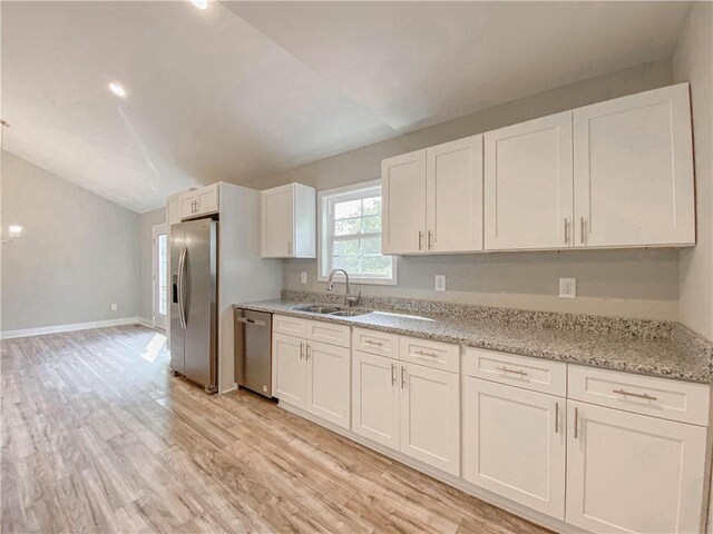 325 Code Cir, Seneca, SC 29678 - kitchen featuring stainless steel appliances, vaulted ceiling, light wood-style floors, white cabinets, and light stone countertops