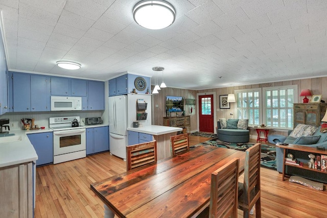 197 Jubie Ln, Seneca, SC 29672 - kitchen with blue cabinets, white appliances, light countertops, light wood-style floors, and wooden walls