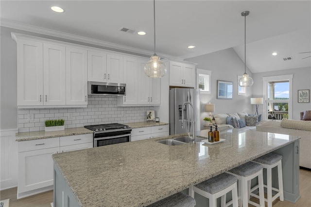 914 Blue Moon St, Taylors, SC 29687 - kitchen with appliances with stainless steel finishes, white cabinetry, light wood finished floors, a kitchen island with sink, and a breakfast bar