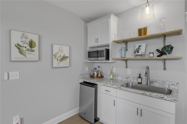 914 Blue Moon St, Taylors, SC 29687 - kitchen featuring stainless steel microwave, open shelves, refrigerator, white cabinets, and light wood-style flooring
