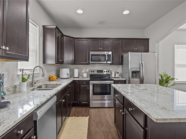 112 Wilbur St, Easley, SC 29640 - kitchen with appliances with stainless steel finishes, dark brown cabinetry, dark wood finished floors, a kitchen island, and light stone counters
