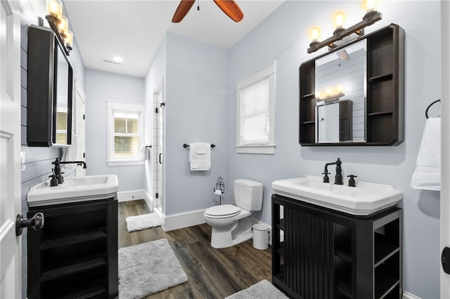 129 N Lawn Dr, Sunset, SC 29685 - bathroom featuring two vanities, wood finished floors, a stall shower, ceiling fan, and plenty of natural light