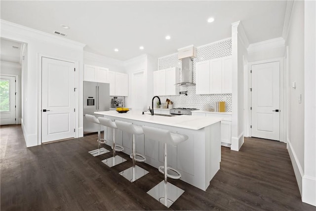 123 Moore Dr, Easley, SC 29642 - kitchen with high end fridge, wall chimney exhaust hood, crown molding, a center island with sink, and decorative backsplash