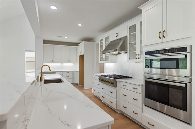 740 Enoree River Pl, Greer, SC 29651 - kitchen featuring stainless steel double oven, under cabinet range hood, gas cooktop, white cabinetry, and light stone counters