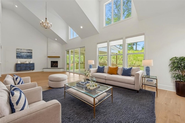 740 Enoree River Pl, Greer, SC 29651 - living room featuring a towering ceiling, a chandelier, light wood-style floors, a fireplace, and recessed lighting