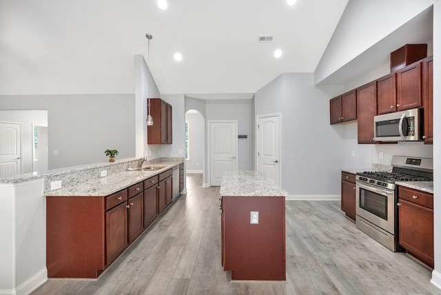 618 Motor Boat Way, Seneca, SC 29672 - kitchen featuring stainless steel appliances, lofted ceiling, arched walkways, a center island, and light wood-type flooring