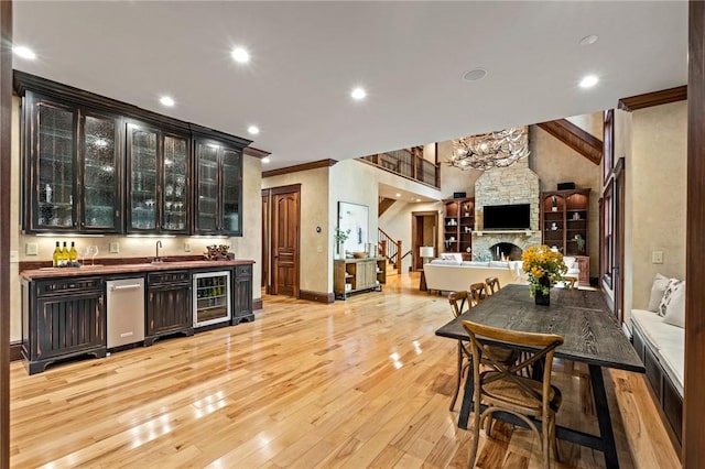 264 Featherstone Dr, Sunset, SC 29685 - indoor wet bar with wine cooler, a stone fireplace, ornamental molding, stainless steel dishwasher, and light wood-type flooring