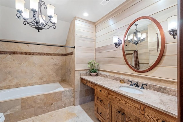 264 Featherstone Dr, Sunset, SC 29685 - bathroom featuring a chandelier, tile walls, a relaxing tiled tub, and vanity