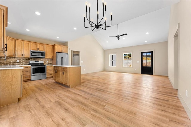 333 Ravens View Dr, Seneca, SC 29678 - kitchen with stainless steel appliances, a kitchen island, light wood-type flooring, vaulted ceiling, and backsplash