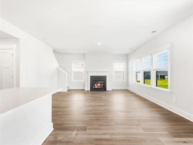 791 Burghley Cir, Greer, SC 29651 - unfurnished living room with light wood-type flooring, stairs, and a fireplace with flush hearth