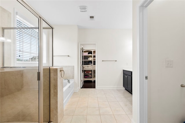100 Dartford Ct, Easley, SC 29642 - bathroom featuring a spacious closet, vanity, a garden tub, a shower stall, and tile patterned flooring