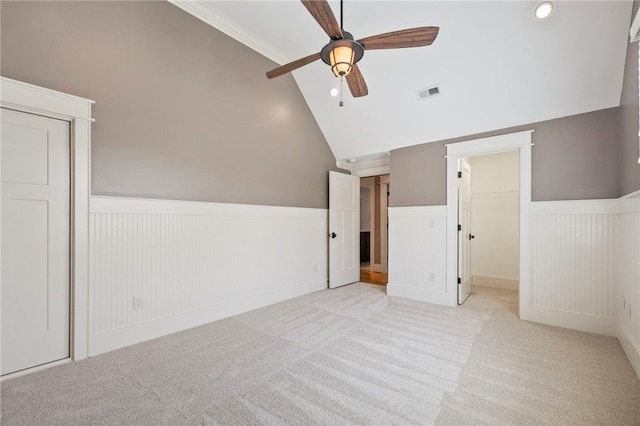 1219 Old Mill Rd, Easley, SC 29642 - unfurnished bedroom featuring light colored carpet, a wainscoted wall, vaulted ceiling, a ceiling fan, and a spacious closet