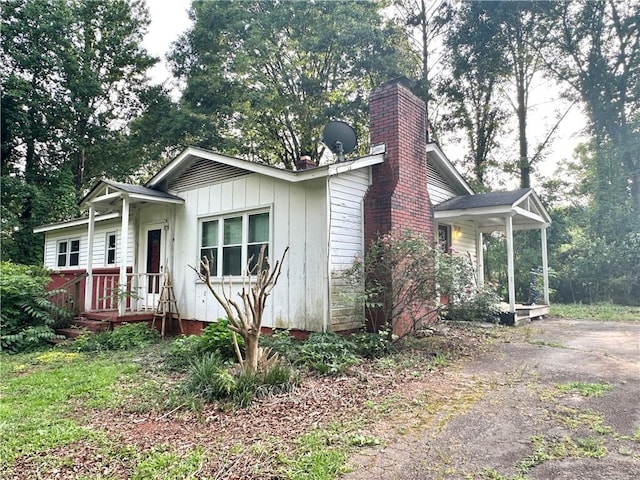 114 Bonnie Brae Ln, Walhalla, SC 29691 - view of front of house featuring a chimney, board and batten siding, asphalt driveway, and view of scattered trees
