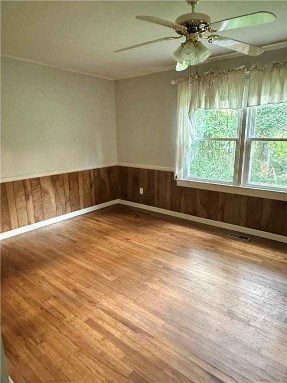 114 Bonnie Brae Ln, Walhalla, SC 29691 - unfurnished room with plenty of natural light, wood finished floors, a ceiling fan, wood walls, and wainscoting
