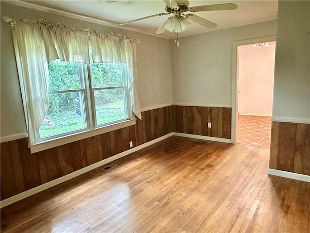 114 Bonnie Brae Ln, Walhalla, SC 29691 - spare room with wood finished floors, wooden walls, a wainscoted wall, ceiling fan, and ornamental molding