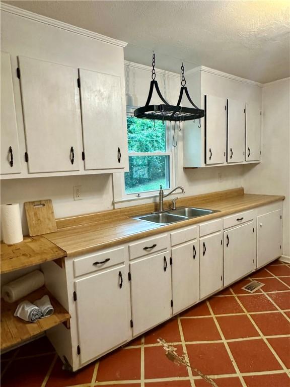 114 Bonnie Brae Ln, Walhalla, SC 29691 - kitchen featuring light countertops, a textured ceiling, white cabinetry, and ornamental molding