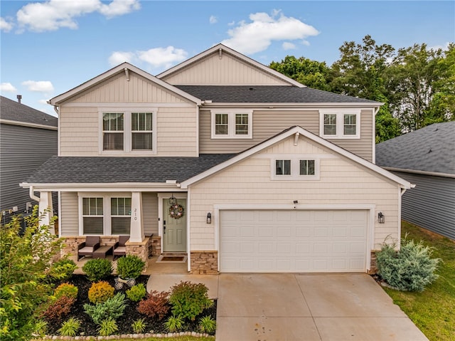 210 Obsidian Ct, Simpsonville, SC 29680 - view of front facade with a shingled roof, concrete driveway, stone siding, outdoor lounge area, and board and batten siding