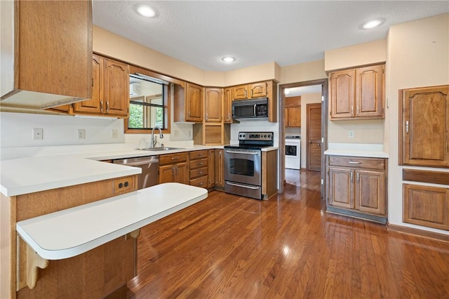 14 Windlass Ct, Salem, SC 29676 - kitchen with stainless steel appliances, a peninsula, dark wood finished floors, brown cabinetry, and recessed lighting