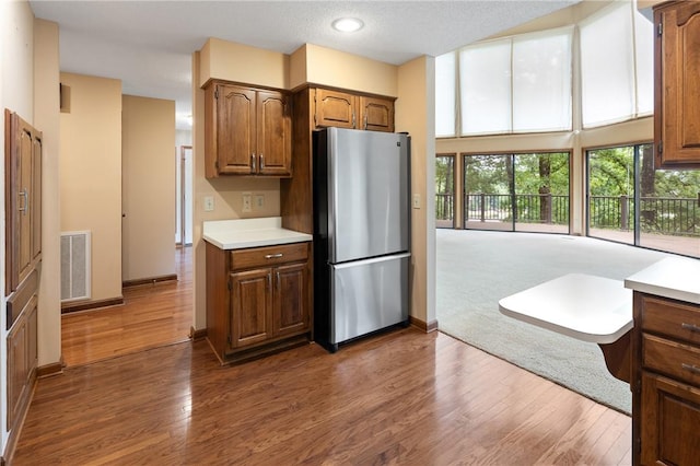 14 Windlass Ct, Salem, SC 29676 - kitchen featuring freestanding refrigerator, light countertops, dark wood-type flooring, brown cabinets, and a textured ceiling