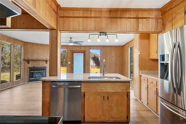 23 Gilmer Dr, Anderson, SC 29621 - kitchen featuring appliances with stainless steel finishes, healthy amount of natural light, wooden walls, a glass covered fireplace, and light wood-style flooring