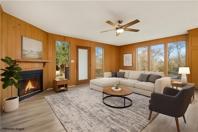 23 Gilmer Dr, Anderson, SC 29621 - living room featuring a ceiling fan, a glass covered fireplace, light wood-type flooring, and wooden walls