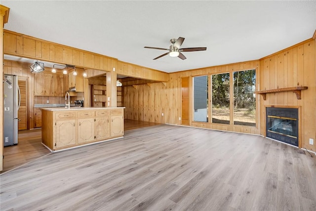 23 Gilmer Dr, Anderson, SC 29621 - unfurnished living room featuring wood walls, a ceiling fan, light wood-style floors, a glass covered fireplace, and ornamental molding
