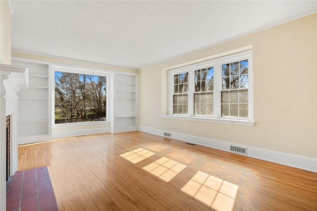 23 Gilmer Dr, Anderson, SC 29621 - unfurnished living room with built in shelves, hardwood / wood-style flooring, and crown molding
