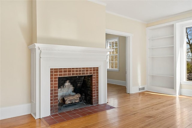23 Gilmer Dr, Anderson, SC 29621 - detailed view of built in shelves, wood finished floors, a tiled fireplace, and crown molding