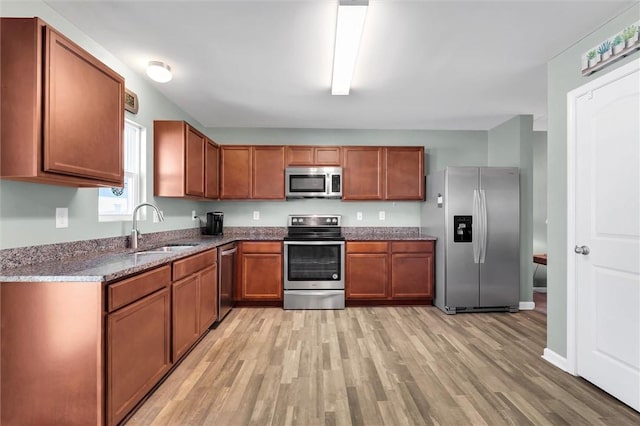 131 Colonial Walk, Pickens, SC 29671 - kitchen with appliances with stainless steel finishes, light wood-style flooring, dark stone counters, and brown cabinetry