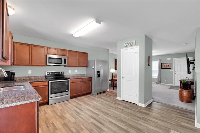 131 Colonial Walk, Pickens, SC 29671 - kitchen featuring stainless steel appliances, light wood-style flooring, brown cabinetry, and light stone counters