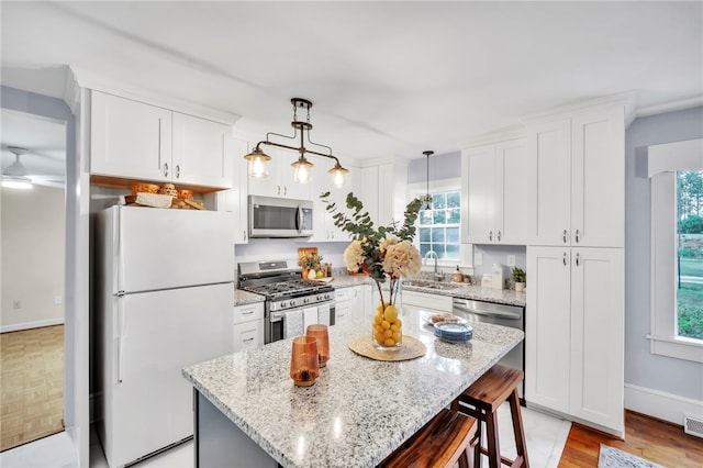 513 Shiloh Rd, Seneca, SC 29678 - kitchen featuring stainless steel appliances, a breakfast bar, white cabinets, and healthy amount of natural light