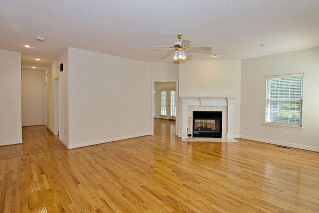 200 Smithfield Dr, Anderson, SC 29621 - unfurnished living room featuring light wood-type flooring, ceiling fan, a textured ceiling, a tiled fireplace, and recessed lighting