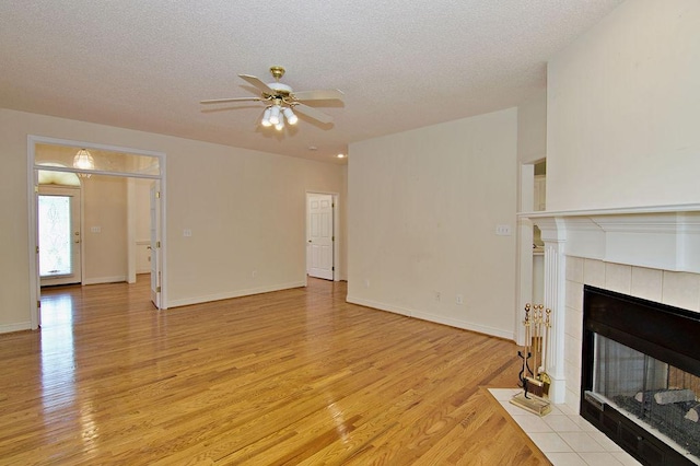 200 Smithfield Dr, Anderson, SC 29621 - unfurnished living room featuring light wood-type flooring, ceiling fan, a tile fireplace, and a textured ceiling