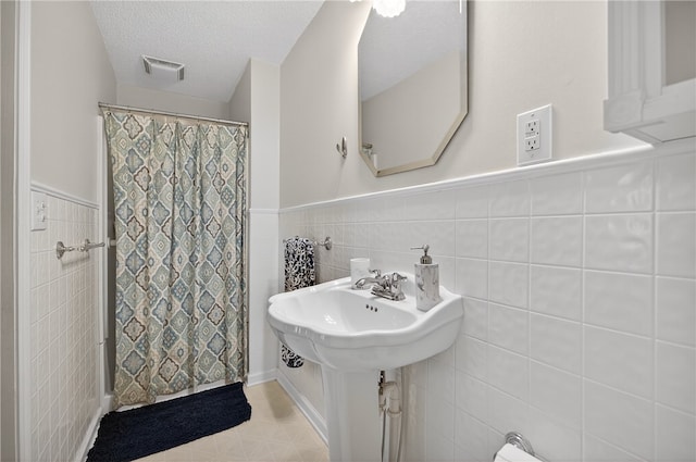 260 Riggs Dr, Clemson, SC 29631 - bathroom featuring tile walls, a wainscoted wall, a shower with curtain, and a textured ceiling