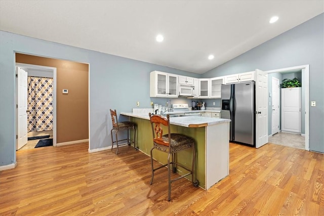 433 Shore Line Dr, Anderson, SC 29626 - kitchen with white appliances, a peninsula, lofted ceiling, a breakfast bar area, and light countertops