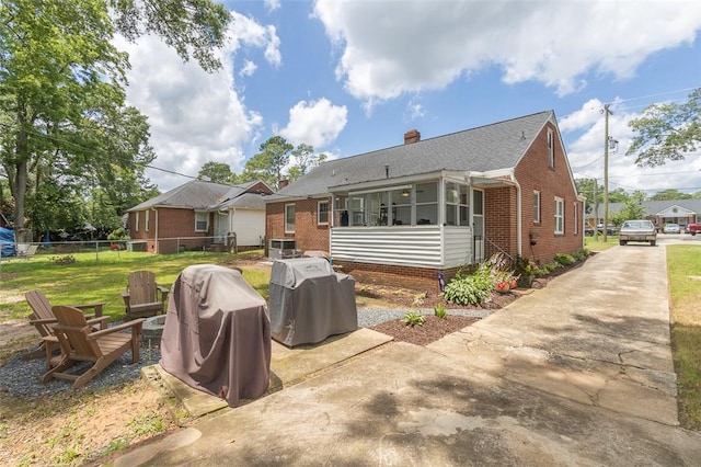 205 James St, Anderson, SC 29625 - rear view of property with brick siding, a chimney, driveway, and a sunroom