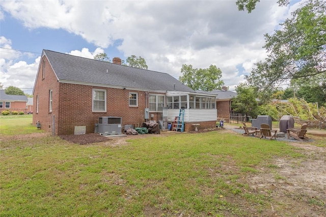 205 James St, Anderson, SC 29625 - back of property with a sunroom, brick siding, a lawn, and a chimney