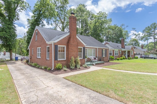 205 James St, Anderson, SC 29625 - view of front of home featuring brick siding, a chimney, driveway, a front yard, and a porch