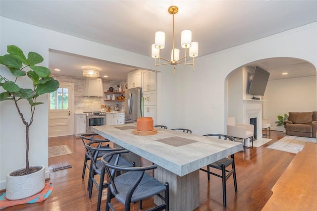 205 James St, Anderson, SC 29625 - dining area with arched walkways, wood finished floors, a fireplace with flush hearth, and a chandelier