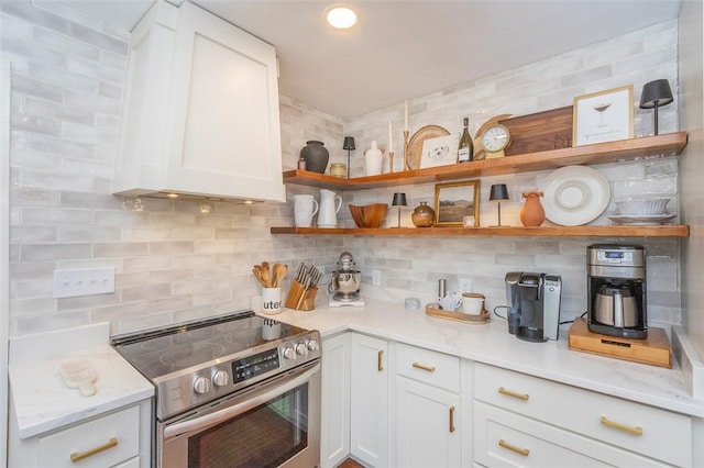 205 James St, Anderson, SC 29625 - kitchen with stainless steel electric range, open shelves, custom range hood, backsplash, and white cabinetry