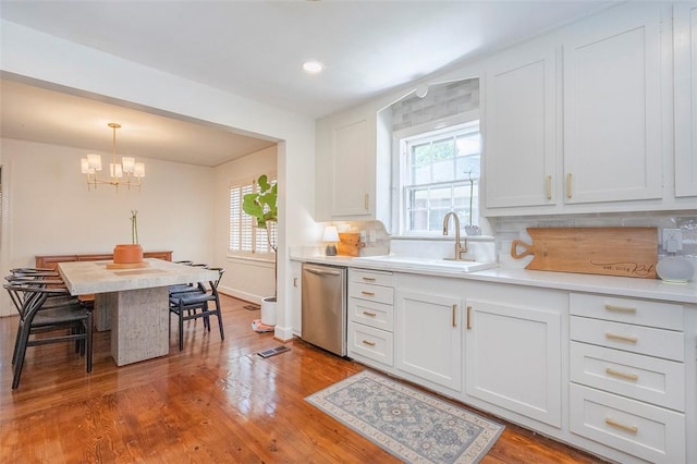 205 James St, Anderson, SC 29625 - kitchen with stainless steel dishwasher, a chandelier, light countertops, white cabinets, and wood finished floors