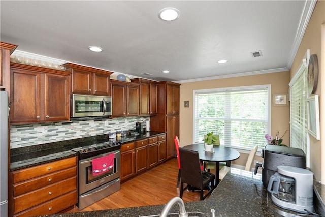 1339 Griffin Mill Rd, Easley, SC 29640 - kitchen featuring appliances with stainless steel finishes, ornamental molding, tasteful backsplash, light wood finished floors, and recessed lighting