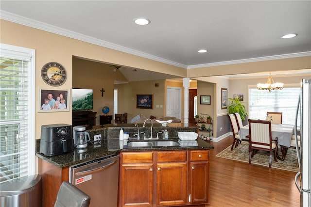 1339 Griffin Mill Rd, Easley, SC 29640 - kitchen with appliances with stainless steel finishes, wood finished floors, decorative columns, ornamental molding, and a chandelier
