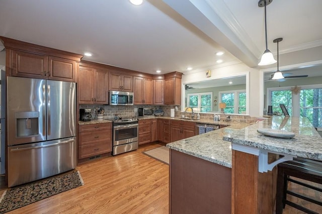 227 E Clearwater Shores Rd, Fair Play, SC 29643 - kitchen featuring appliances with stainless steel finishes, ornamental molding, light wood-style floors, a breakfast bar, and a peninsula