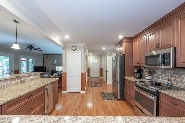 227 E Clearwater Shores Rd, Fair Play, SC 29643 - kitchen featuring stainless steel appliances, ornamental molding, light wood finished floors, brown cabinetry, and light stone countertops