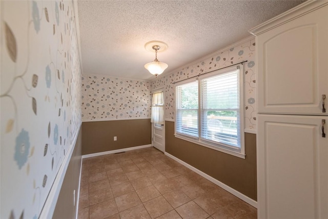 208 Springview Dr, Anderson, SC 29625 - unfurnished dining area with wallpapered walls, a textured ceiling, light tile patterned floors, and crown molding