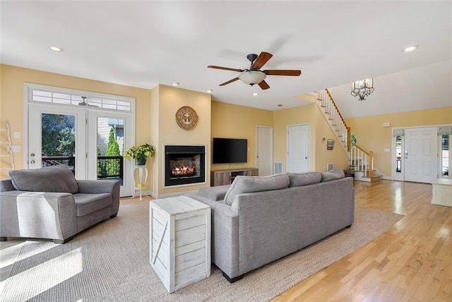 223 Inlet Pointe Dr, Anderson, SC 29625 - living room featuring stairway, light wood-type flooring, a warm lit fireplace, ceiling fan, and recessed lighting