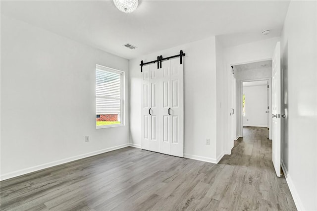 1938 Inman Dr, Anderson, SC 29625 - unfurnished bedroom featuring wood finished floors, a barn door, and a closet