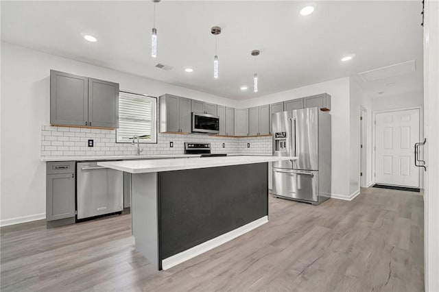 1938 Inman Dr, Anderson, SC 29625 - kitchen with stainless steel appliances, gray cabinets, tasteful backsplash, light countertops, and light wood finished floors